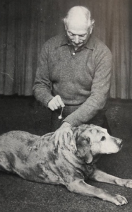 Bruce MacManaway using a pendulum to diagnose illness in a dog photo by Janet Banks
